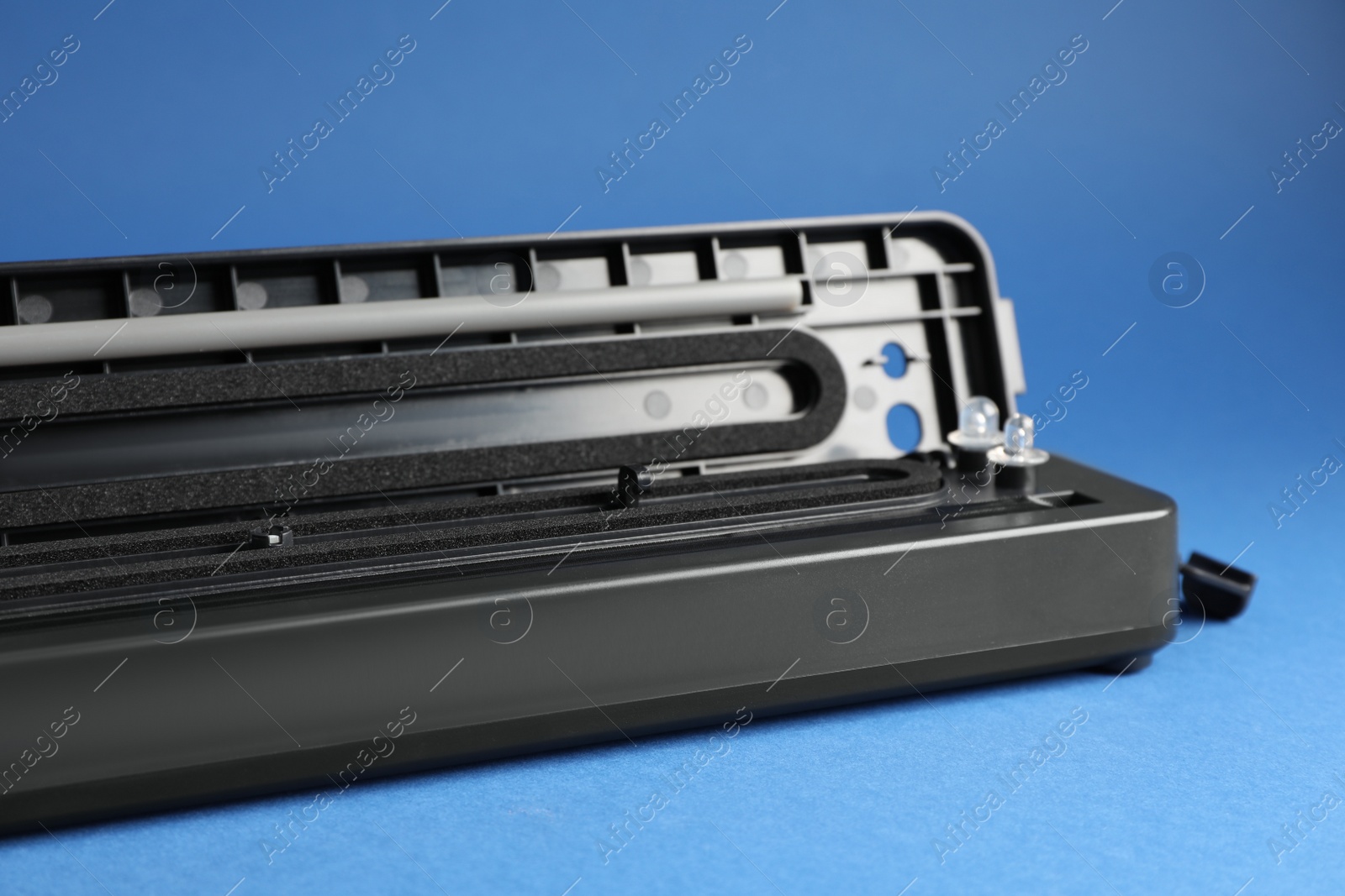 Photo of Sealer for vacuum packing on blue background, closeup