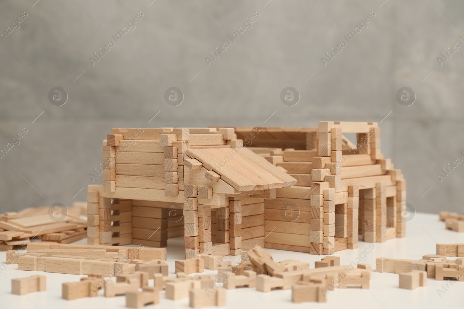 Photo of Wooden construction set on white table, space for text. Children's toy