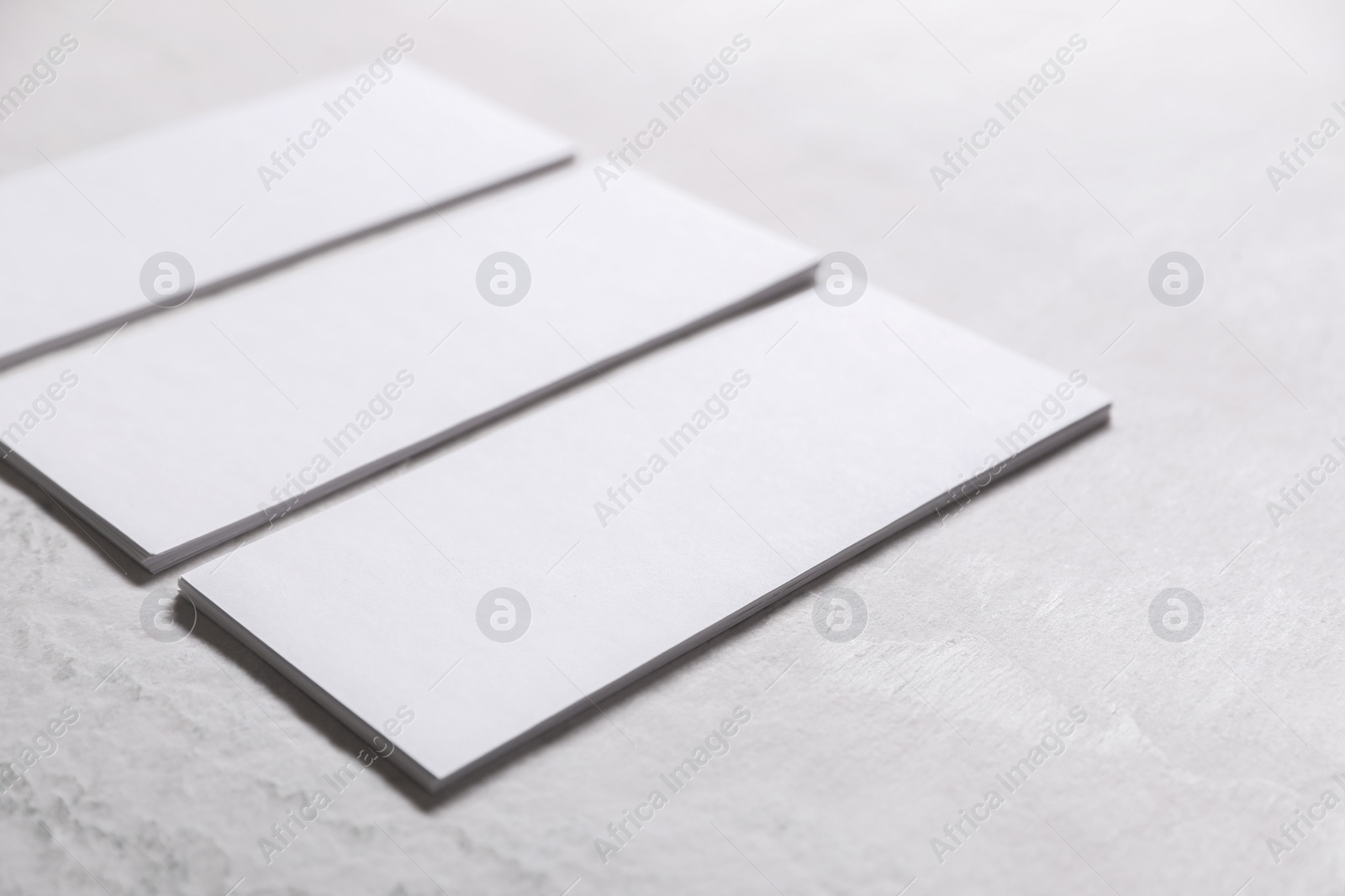 Photo of Blank business cards on light textured table, closeup. Mockup for design