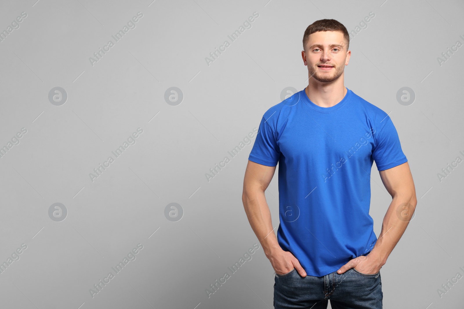 Photo of Man wearing blue t-shirt on light grey background. Mockup for design