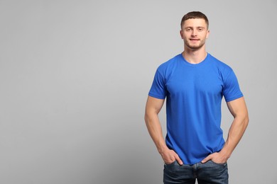 Photo of Man wearing blue t-shirt on light grey background. Mockup for design