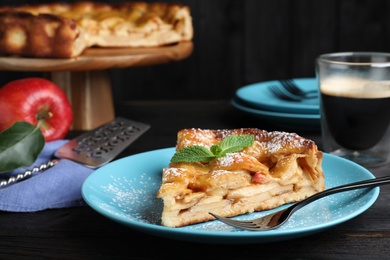 Photo of Slice of traditional apple pie served on black wooden table