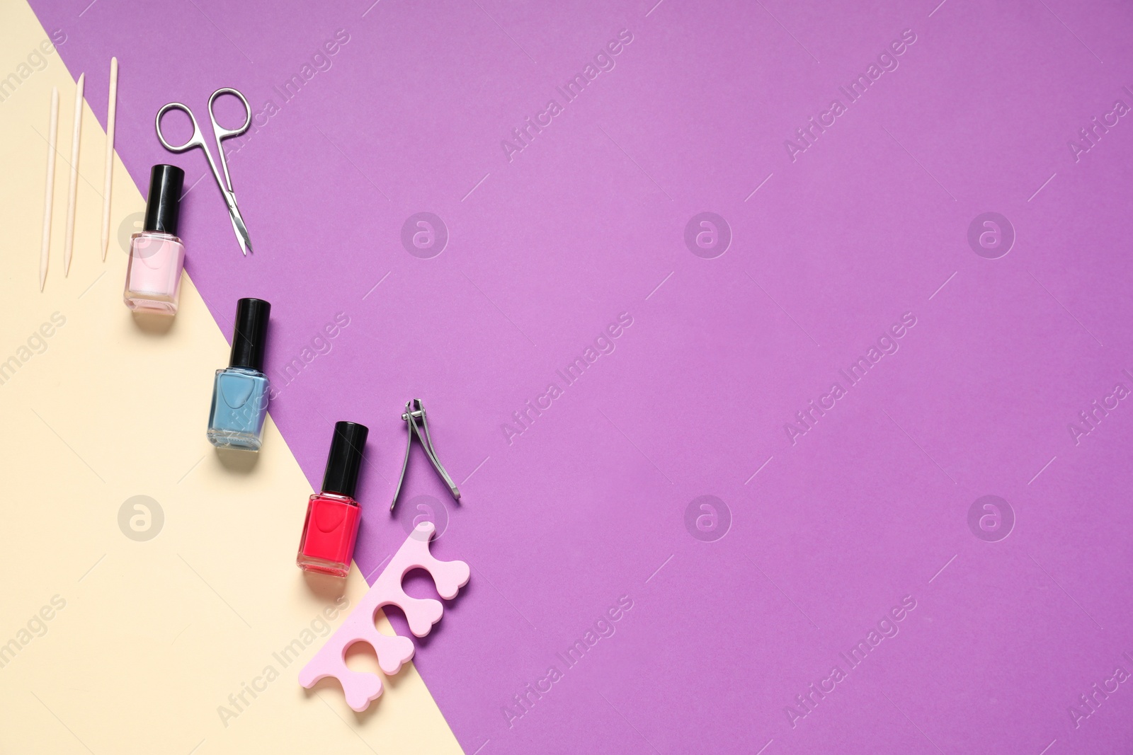 Photo of Nail polishes and set of pedicure tools on color background, flat lay. Space for text