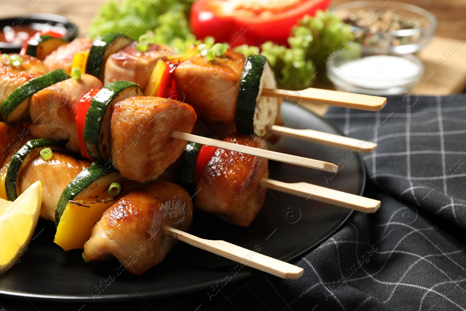 Photo of Delicious chicken shish kebabs with vegetables on plate, closeup