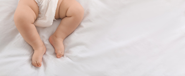 Image of Cute little baby lying on bed, top view with space for text. Banner design