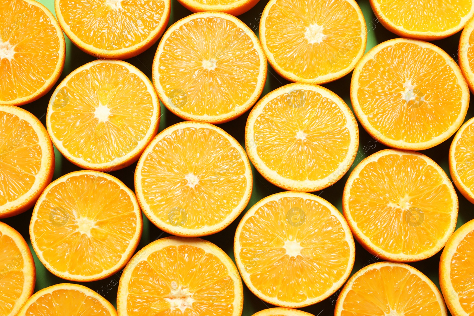 Photo of Halves of ripe oranges as background, top view