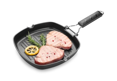 Photo of Grill pan with delicious tuna steaks, lemon and rosemary on white background