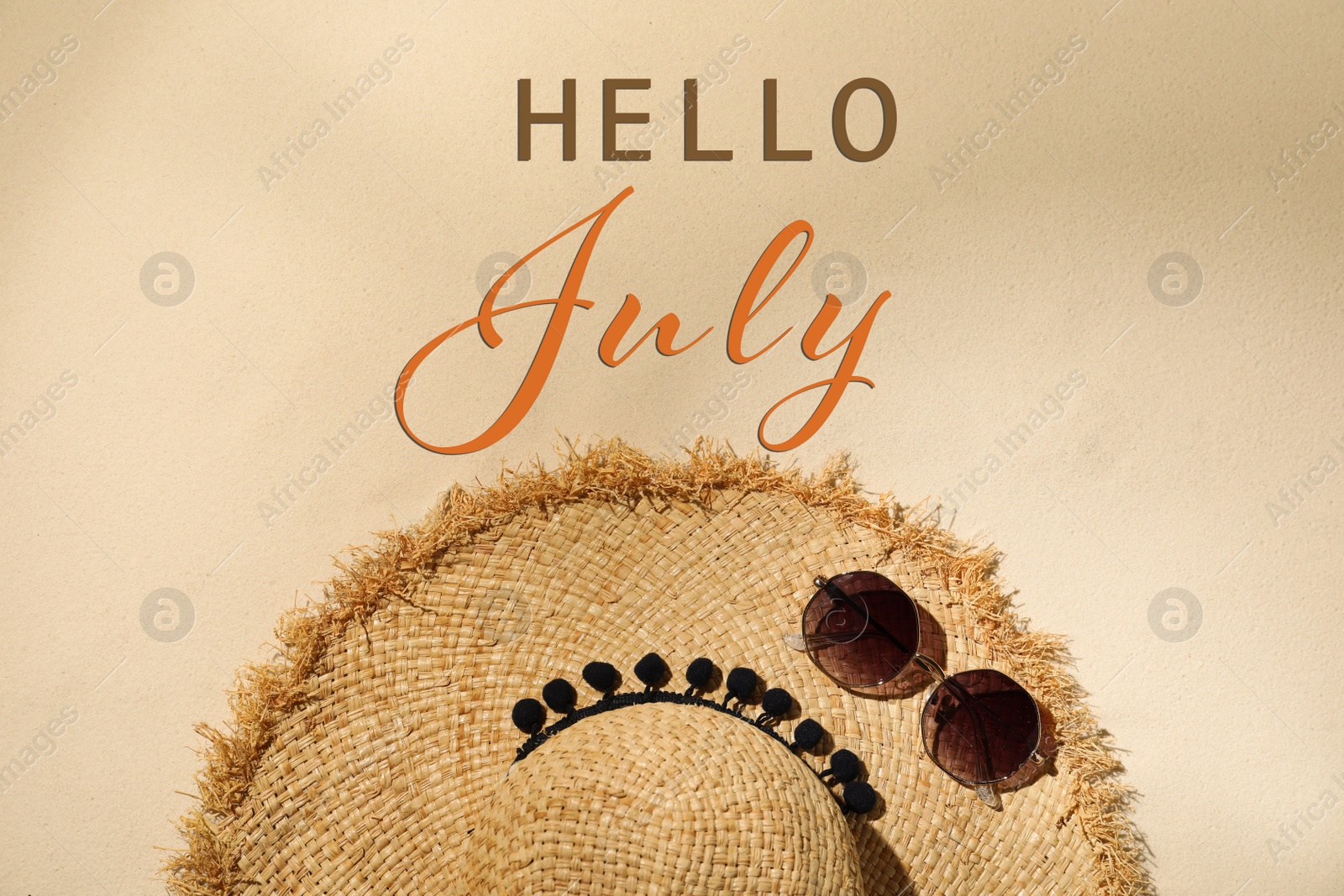 Image of Hello July. Hat and sunglasses on sand, flat lay