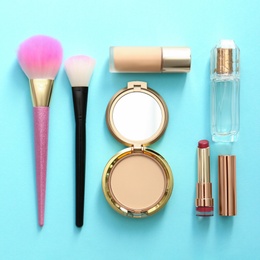 Flat lay composition with bottle of perfume and decorative cosmetics on color background