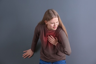 Photo of Young woman having heart attack on gray background