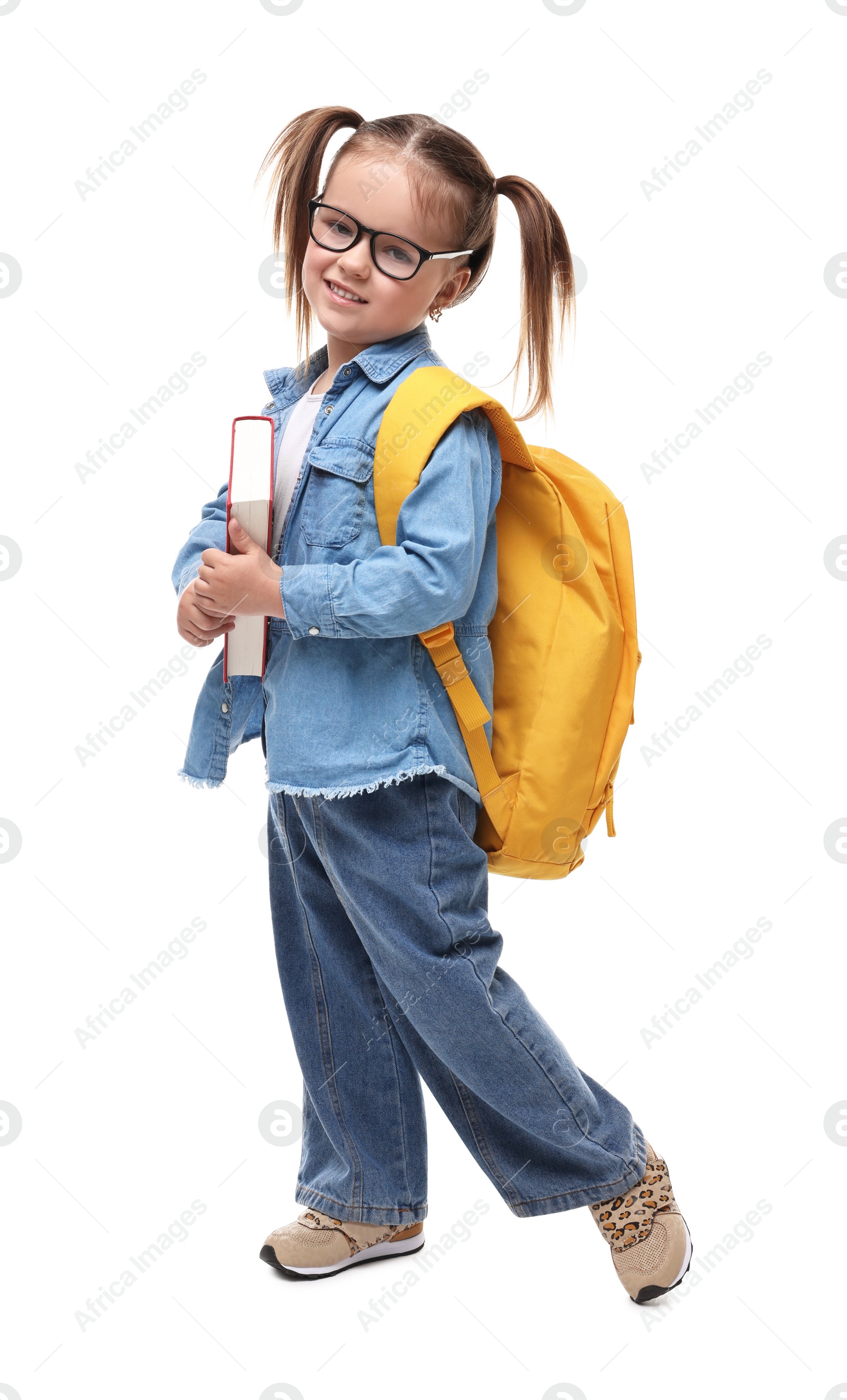 Photo of Cute little girl in glasses with book and backpack on white background