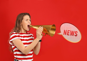 Young woman with megaphone on red background