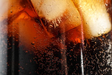 Photo of Glass of refreshing soda drink with ice cubes as background, closeup
