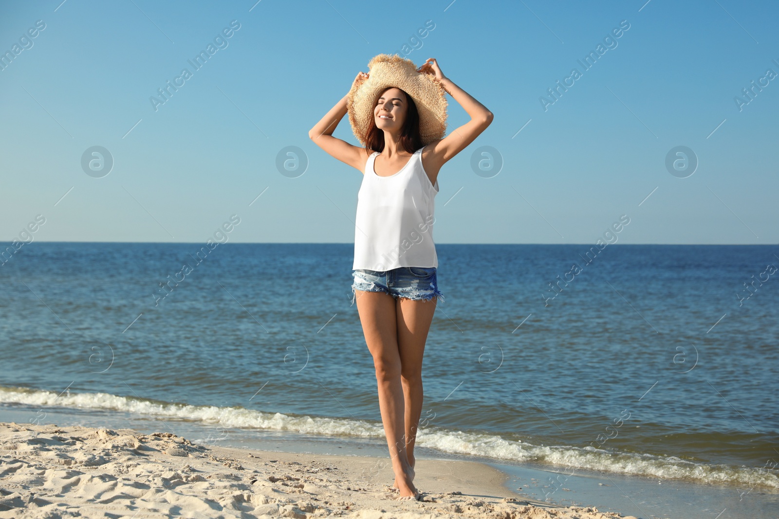 Photo of Beautiful young woman in casual outfit on beach