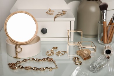 Photo of Jewelry box with mirror and stylish golden bijouterie on dressing table