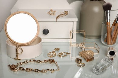 Jewelry box with mirror and stylish golden bijouterie on dressing table