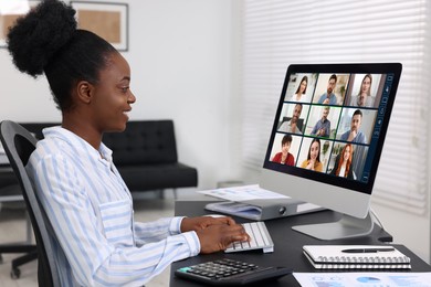 Image of Woman having video chat with coworkers at office