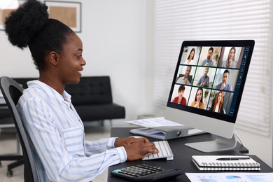 Woman having video chat with coworkers at office