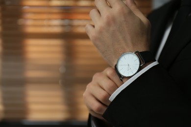 Photo of Businessman with luxury wrist watch indoors, closeup. Space for text