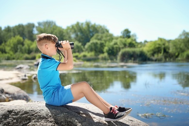Little boy with binoculars outdoors. Summer camp