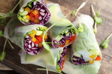 Photo of Delicious spring rolls wrapped in rice paper on table, closeup