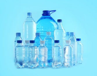 Set of different plastic bottles with pure water on color background