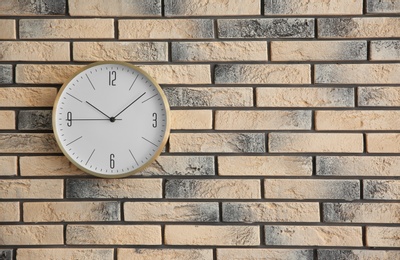 Photo of Stylish clock on brick wall. Time concept