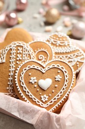 Photo of Tasty heart shaped gingerbread cookies in box, closeup