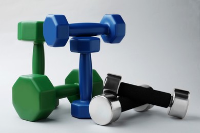 Photo of Set of vinyl and metal dumbbells on light background