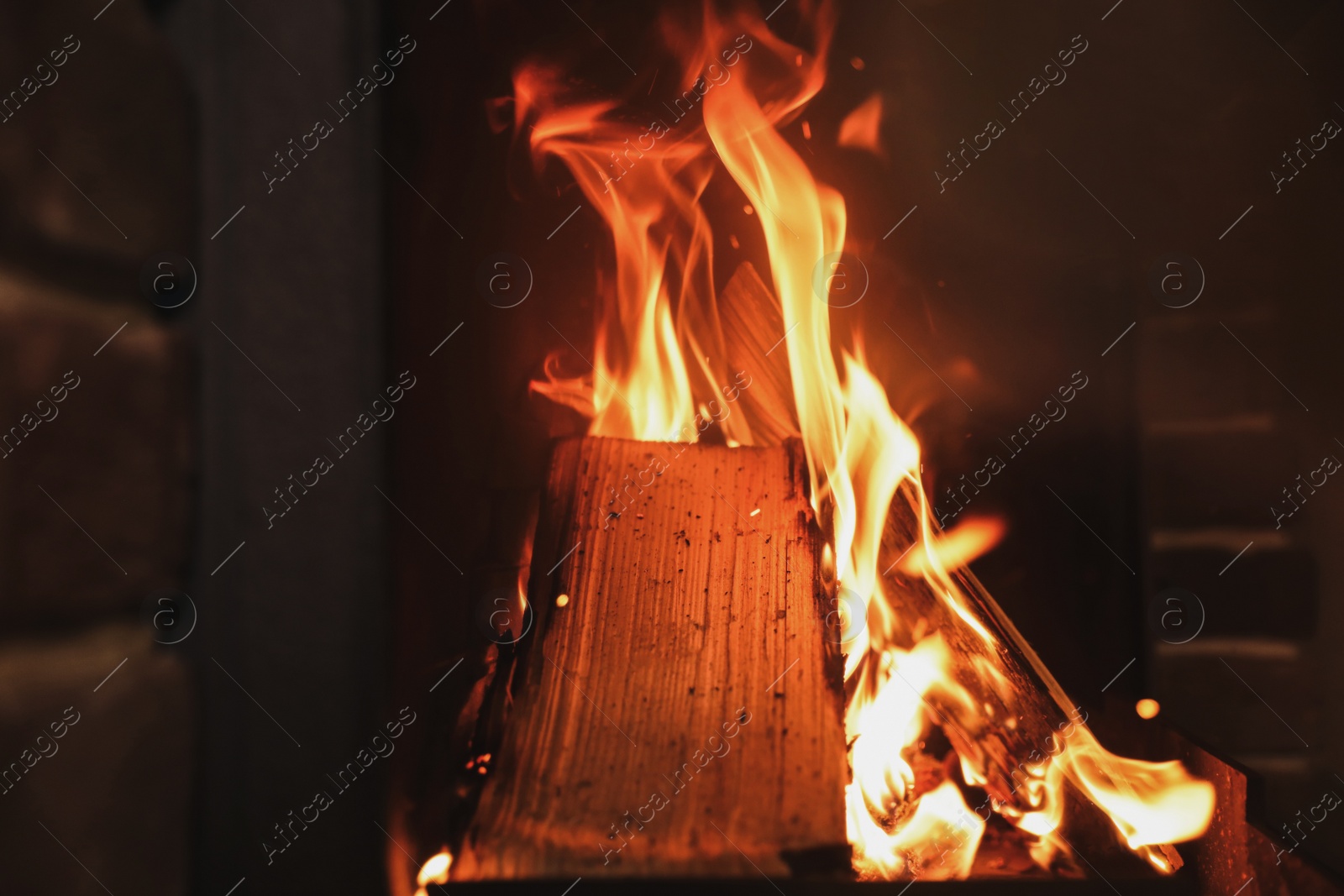 Photo of Fireplace with burning wood, closeup view. Winter vacation