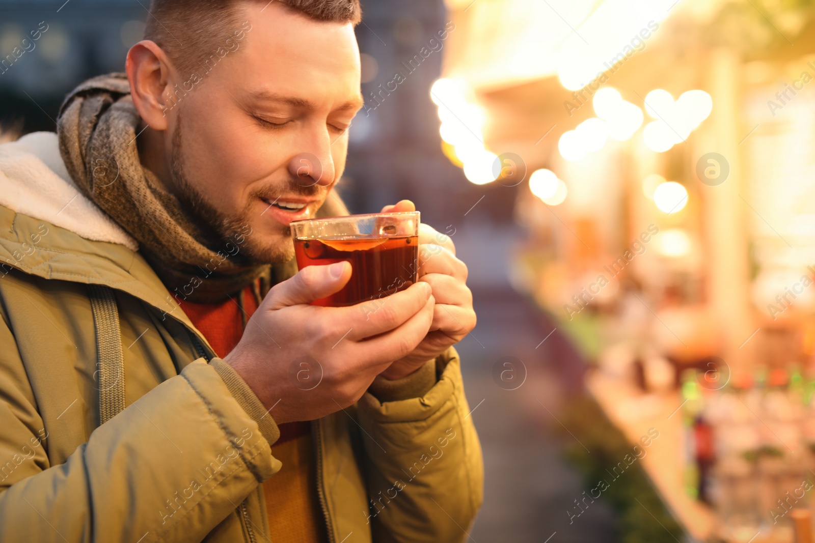 Photo of Happy man with mulled wine at winter fair