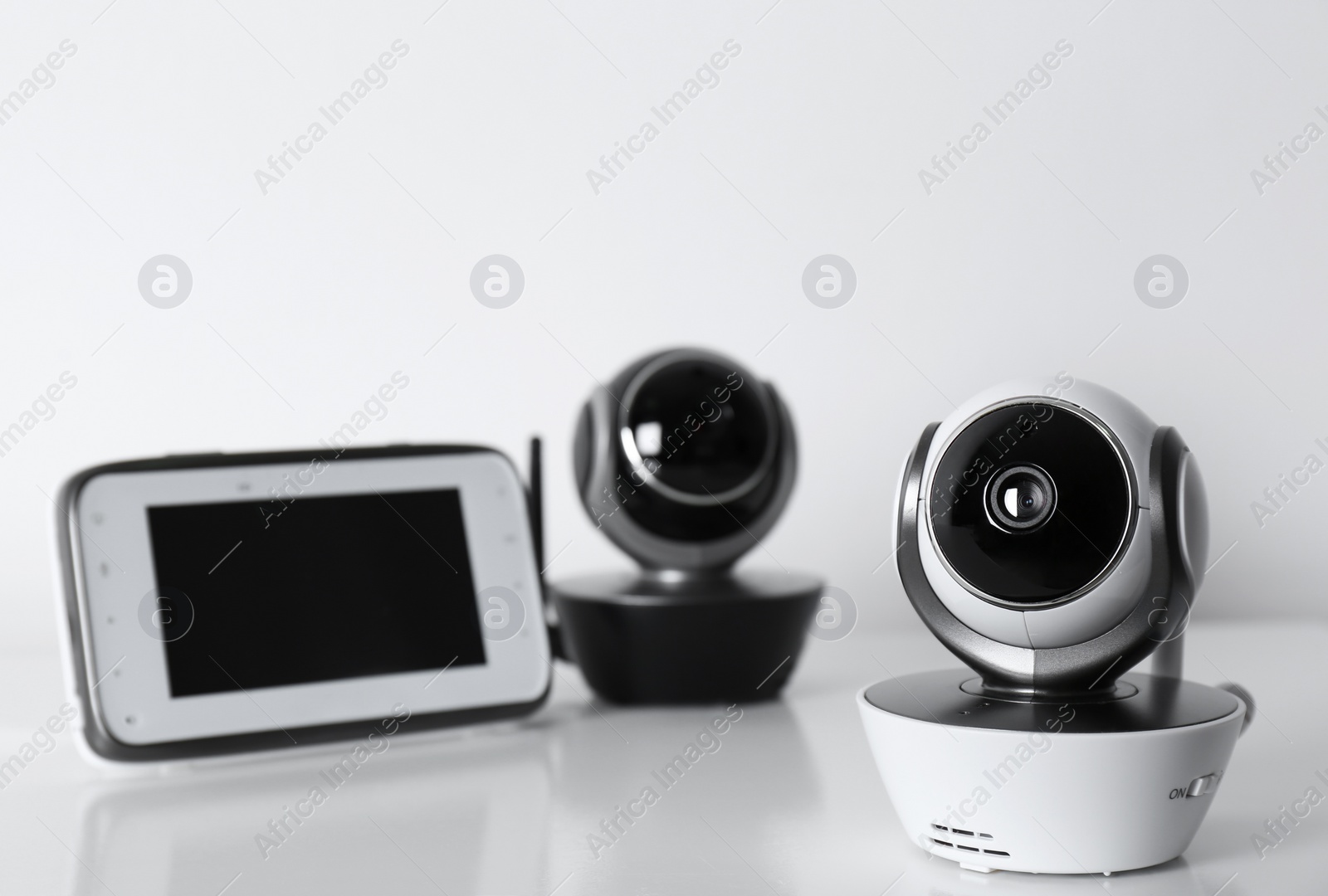 Photo of Modern CCTV security cameras and monitor on white background