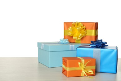 Colorful gift boxes on wooden table against white background, space for text