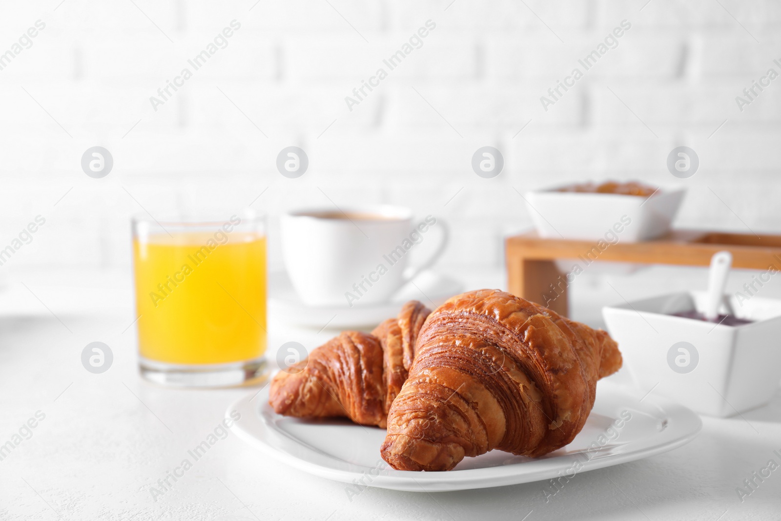 Photo of Fresh croissants and juice on white table. Tasty breakfast