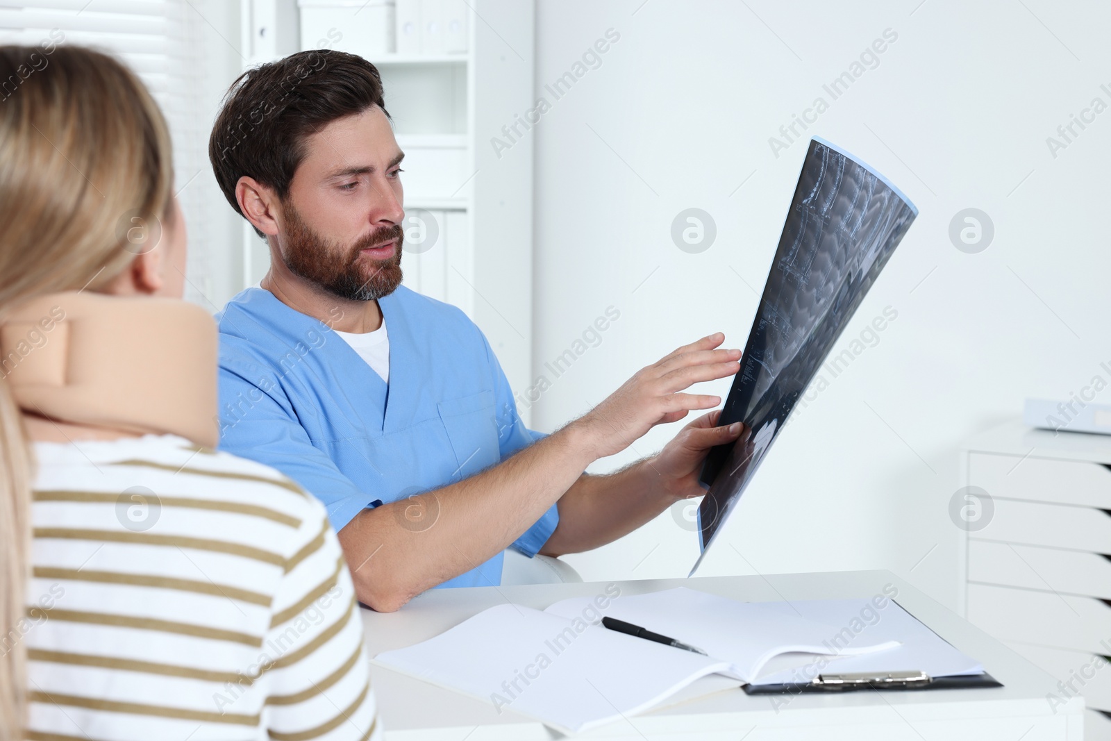 Photo of Doctor with neck MRI scan consulting patient in hospital