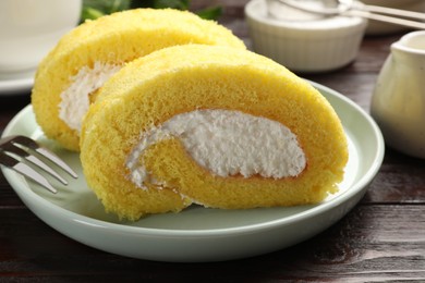 Photo of Delicious cake roll served on wooden table, closeup