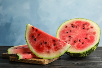 Photo of Wooden board with juicy watermelon slices on table