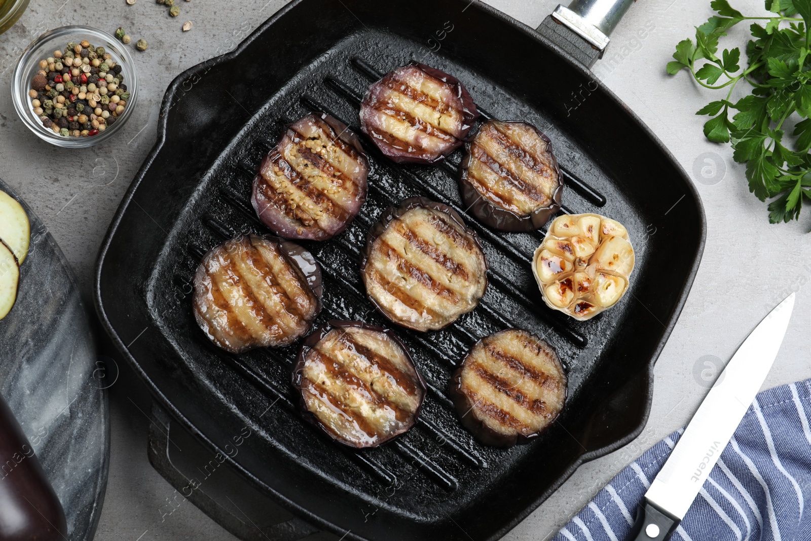 Photo of Delicious grilled eggplant slices in pan on grey table, flat lay