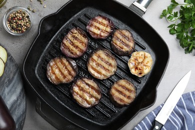 Photo of Delicious grilled eggplant slices in pan on grey table, flat lay