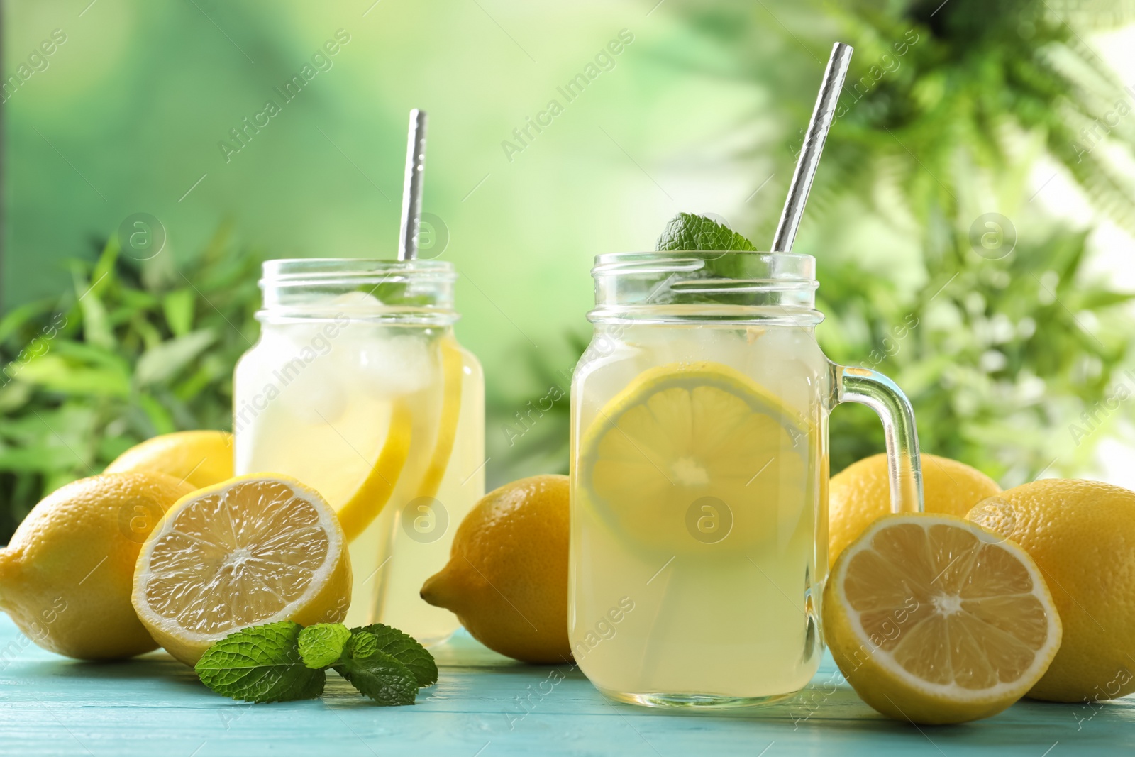 Photo of Natural lemonade with mint on light blue wooden table. Summer refreshing drink