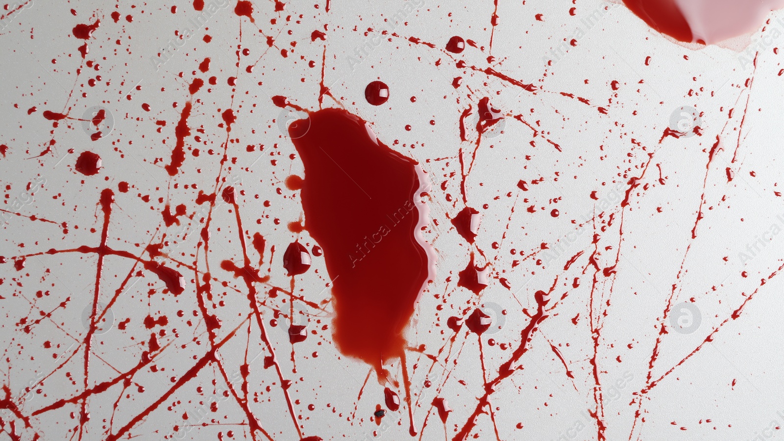 Photo of Stain and splashes of blood on light grey background, top view