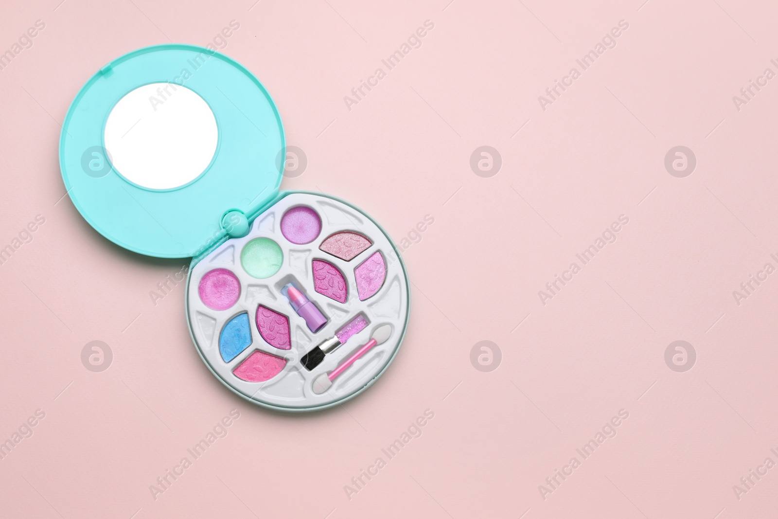 Photo of Decorative cosmetics for kids. Eye shadow palette with lipstick on pink background, top view. Space for text