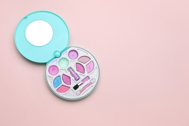 Photo of Decorative cosmetics for kids. Eye shadow palette with lipstick on pink background, top view. Space for text