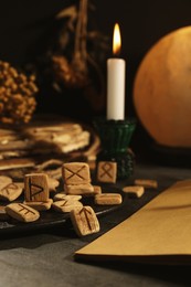 Composition with wooden runes and old books on black table