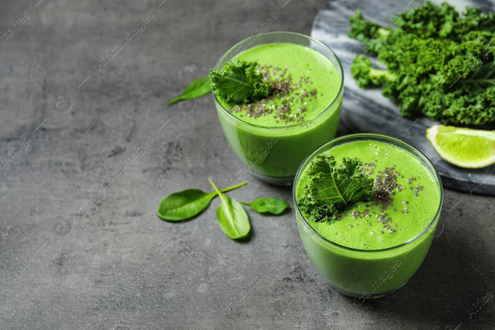 Photo of Tasty kale smoothie with chia seeds on grey table