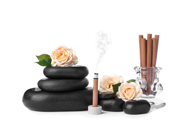 Composition with smoldering incense stick, roses and spa stones on white background