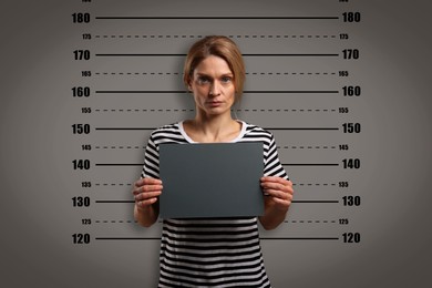 Image of Criminal mugshot. Arrested woman with blank card against height chart