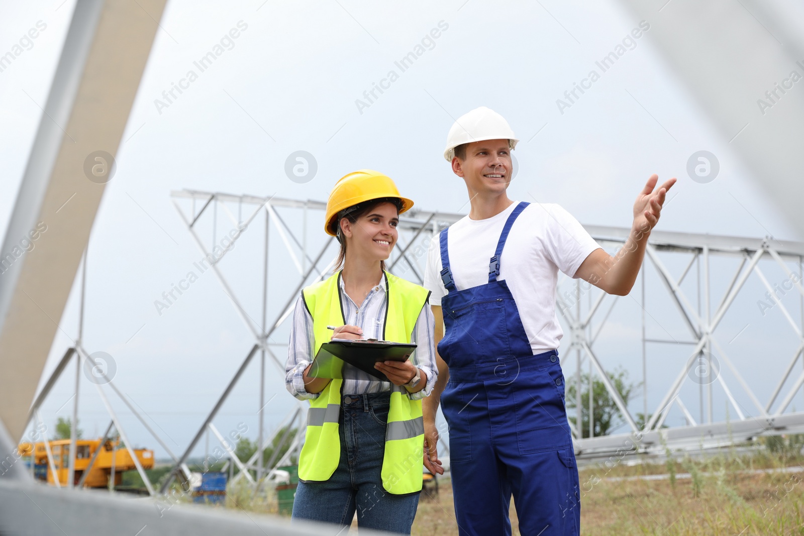 Photo of Professional engineers working on installation of electrical substation outdoors