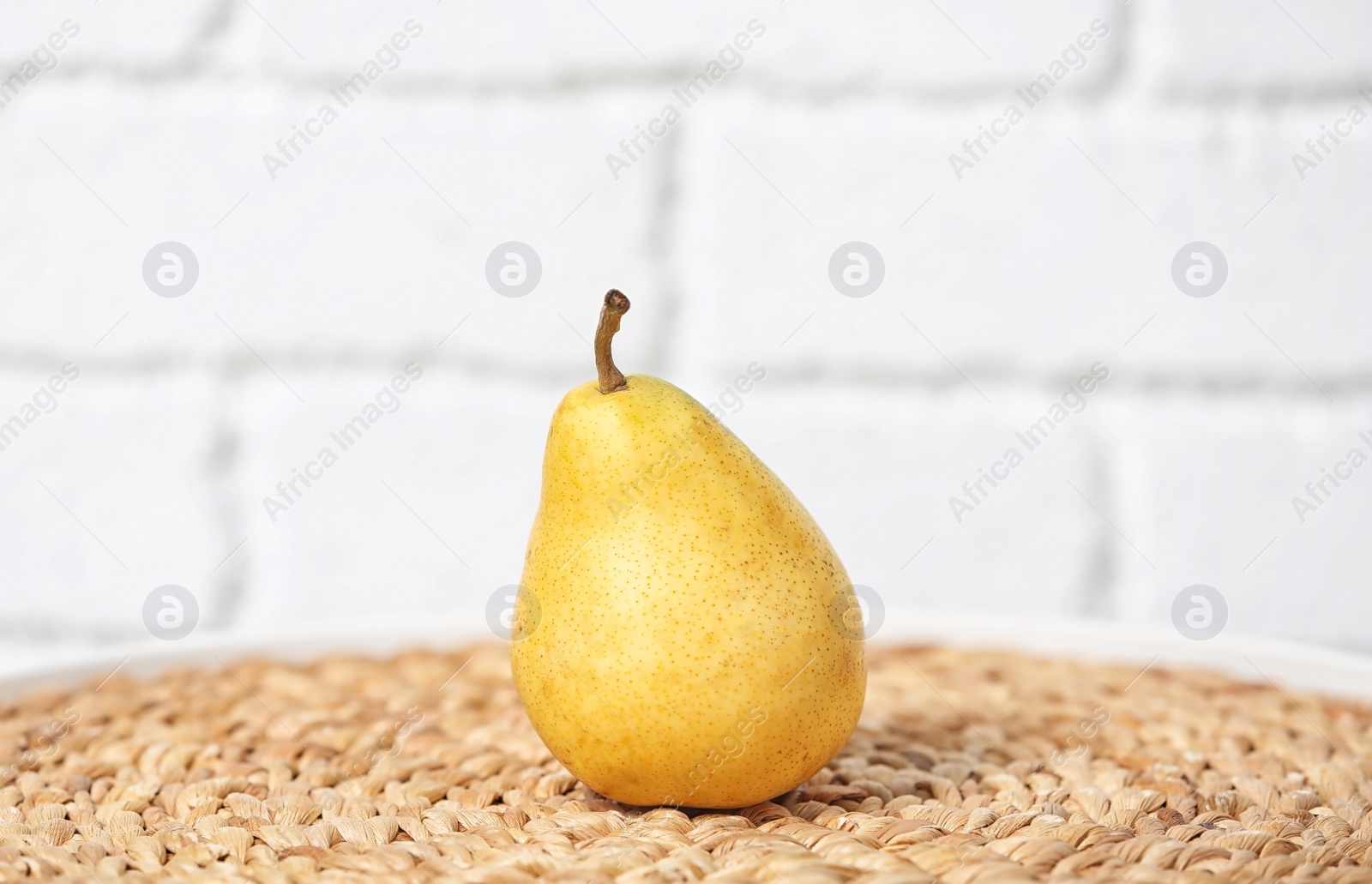 Photo of Ripe pear on table near brick wall