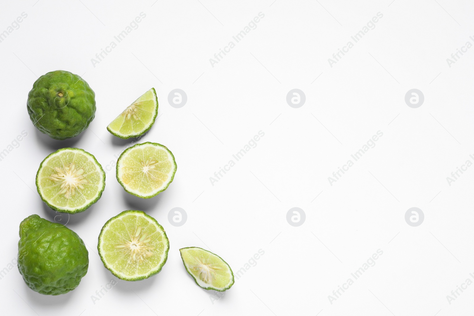 Photo of Whole and cut ripe bergamot fruits on white background, flat lay. Space for text